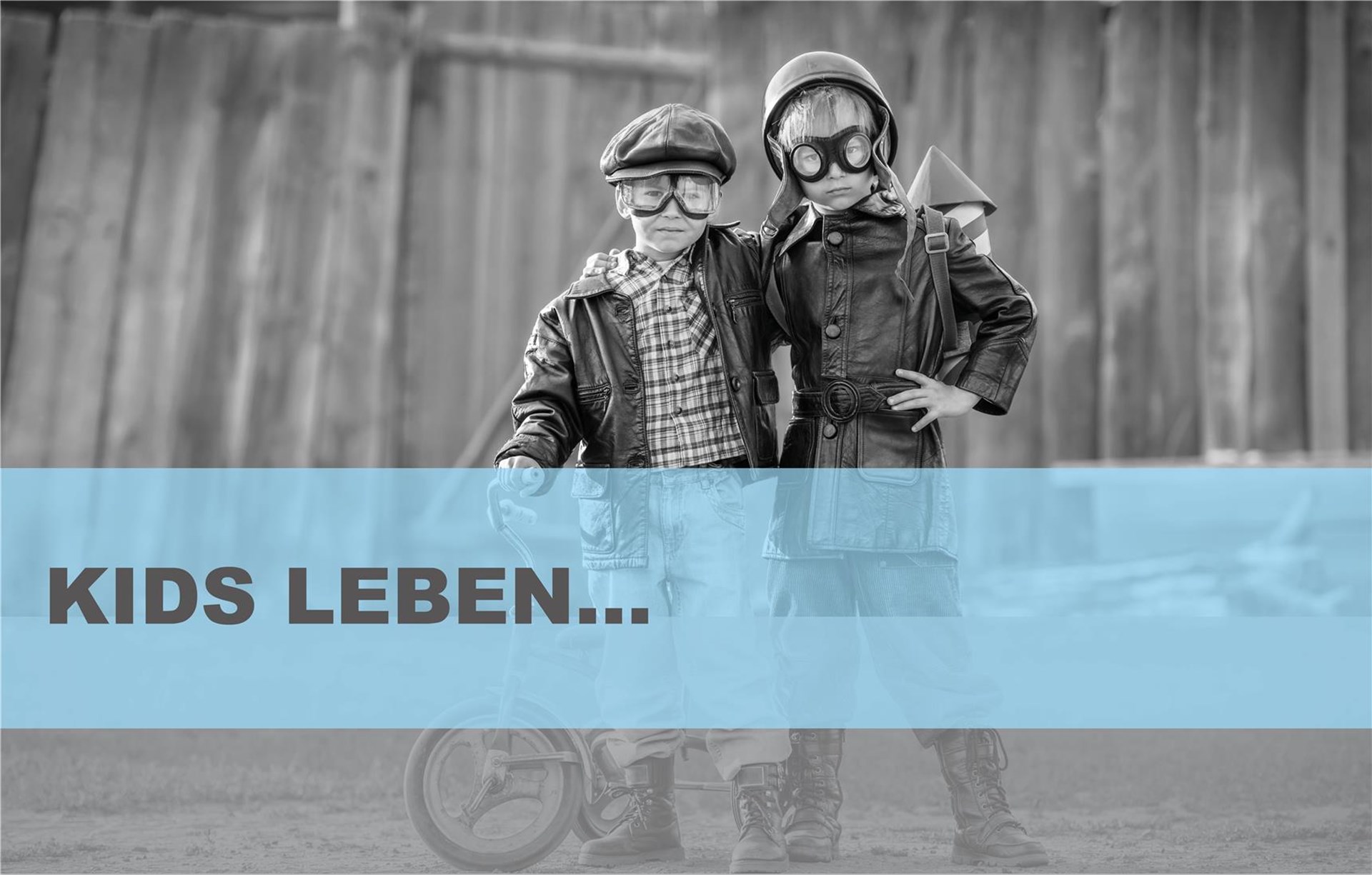 Zwei Jungen in Abenteuermontur halten sich in den Armen und schauen breitbeinig nach vorne. 